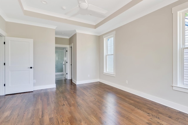 spare room featuring crown molding, a raised ceiling, dark hardwood / wood-style floors, and ceiling fan