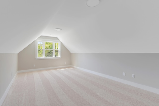 bonus room featuring light carpet and vaulted ceiling