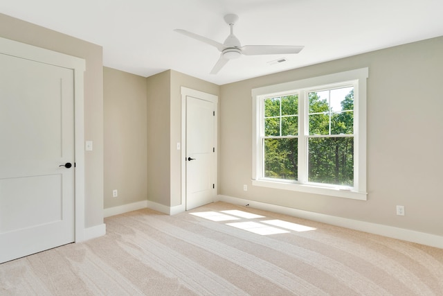 unfurnished bedroom featuring light colored carpet and ceiling fan