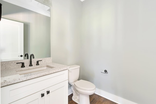 bathroom with vanity, toilet, and hardwood / wood-style flooring