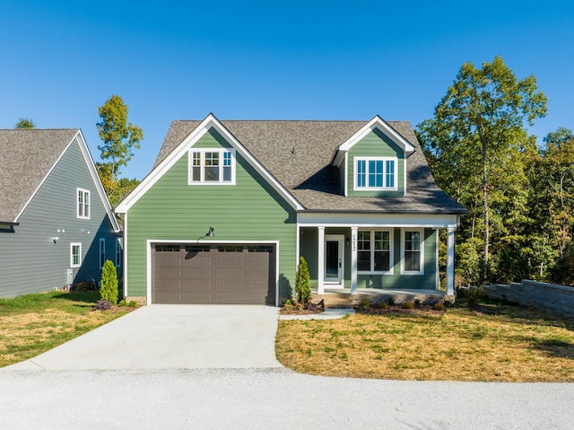 view of front of house featuring a front yard, covered porch, and a garage