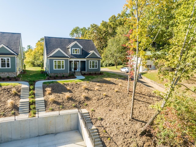 cape cod home featuring a front yard