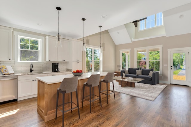 kitchen featuring sink, a center island, hanging light fixtures, dishwasher, and white cabinets