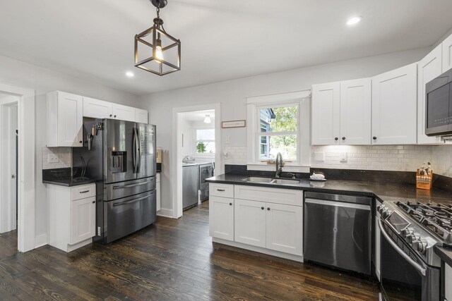 kitchen featuring sink, white cabinets, dark wood-type flooring, and appliances with stainless steel finishes