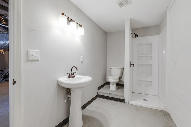 bathroom with sink, toilet, concrete flooring, and walk in shower