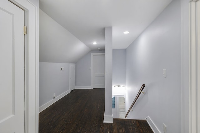 hallway with dark hardwood / wood-style flooring and vaulted ceiling