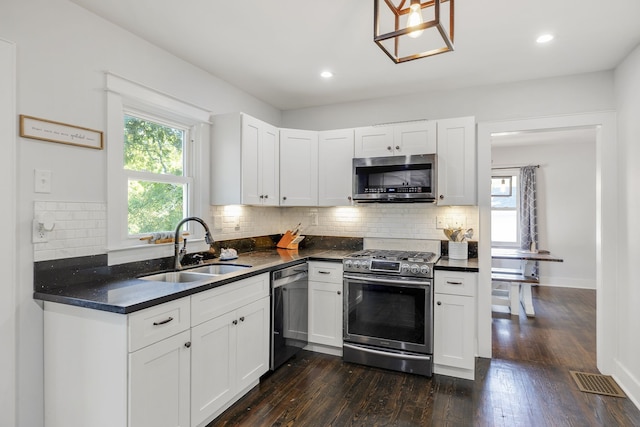 kitchen with stainless steel appliances, white cabinetry, dark hardwood / wood-style floors, and sink