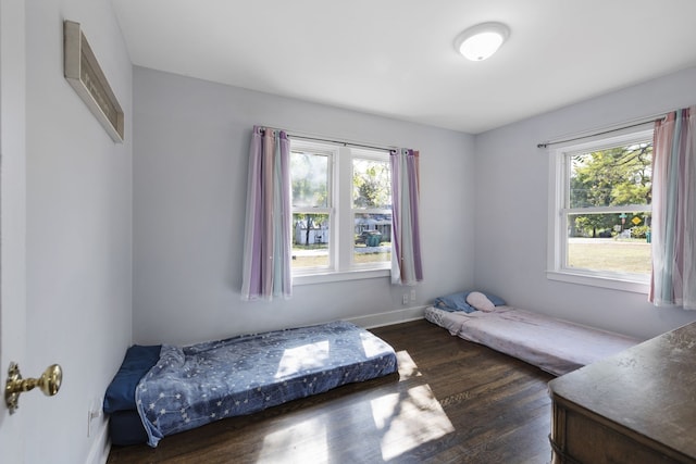 bedroom with dark hardwood / wood-style flooring