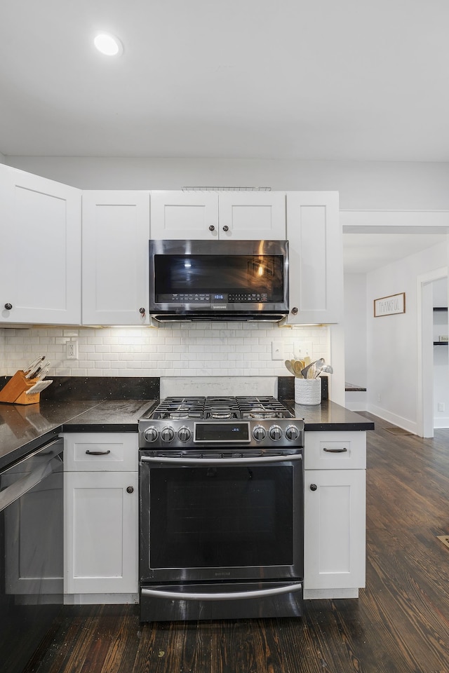 kitchen with tasteful backsplash, white cabinetry, dark wood-type flooring, and stainless steel appliances