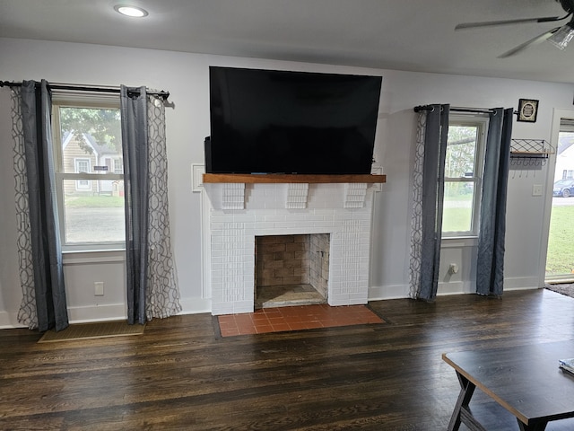 unfurnished living room featuring ceiling fan, a fireplace, and dark hardwood / wood-style floors