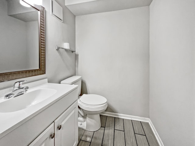 bathroom with hardwood / wood-style floors, toilet, and vanity