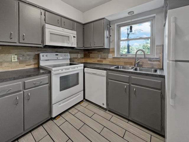 kitchen featuring backsplash, white appliances, sink, gray cabinets, and pendant lighting