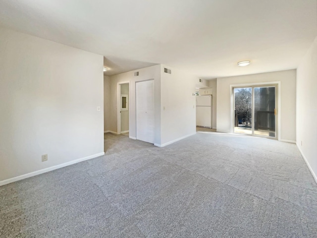 spare room featuring baseboards, visible vents, and carpet flooring