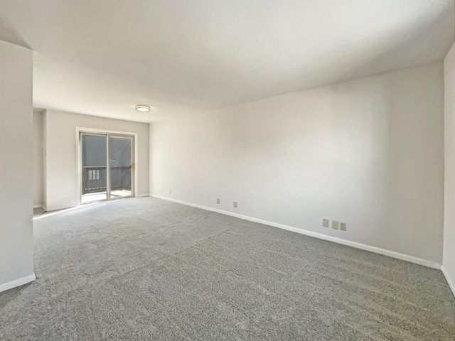 spare room featuring carpet flooring and baseboards