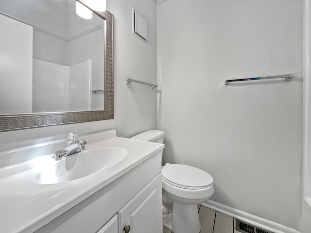 full bath with baseboards, visible vents, vanity, and toilet