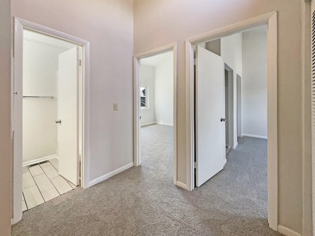 hall featuring carpet and baseboards