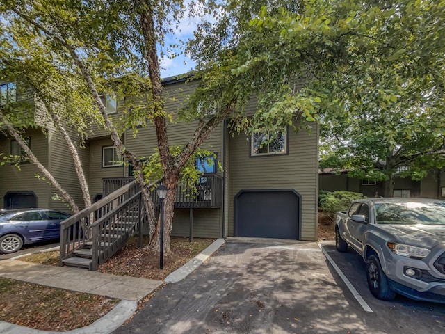 multi unit property featuring stairs and an attached garage