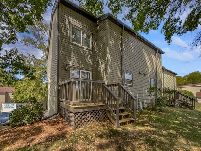 rear view of property featuring a yard and a wooden deck