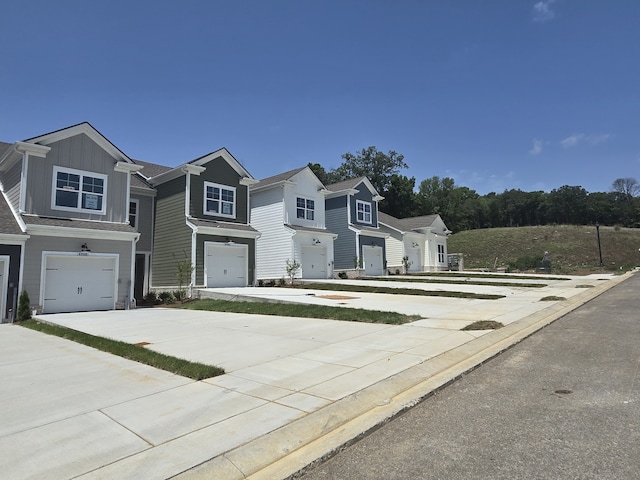 view of front facade with a garage, board and batten siding, and driveway