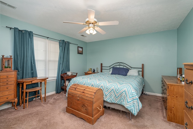 carpeted bedroom with a textured ceiling and ceiling fan