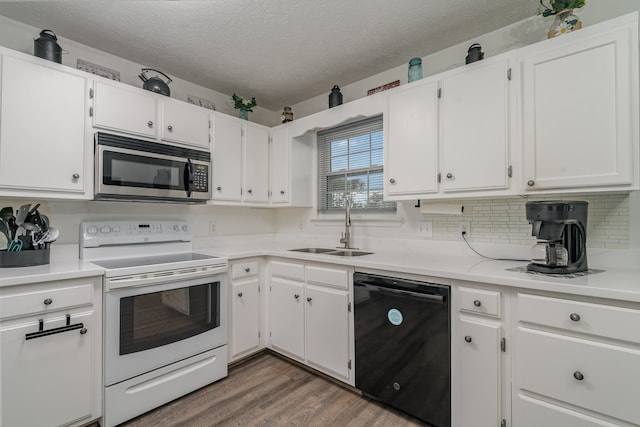 kitchen featuring black dishwasher, sink, white range with electric cooktop, and white cabinetry