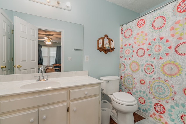 bathroom featuring toilet, a shower with shower curtain, vanity, a textured ceiling, and ceiling fan