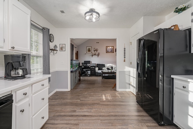 kitchen with black appliances, white cabinets, a textured ceiling, and dark hardwood / wood-style flooring