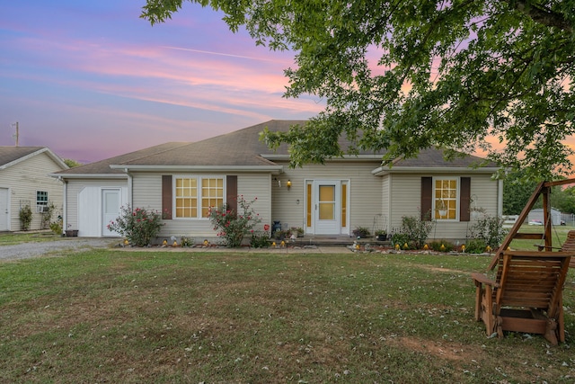 single story home with a lawn