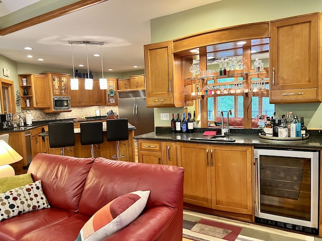 kitchen with built in appliances, beverage cooler, sink, decorative backsplash, and hanging light fixtures