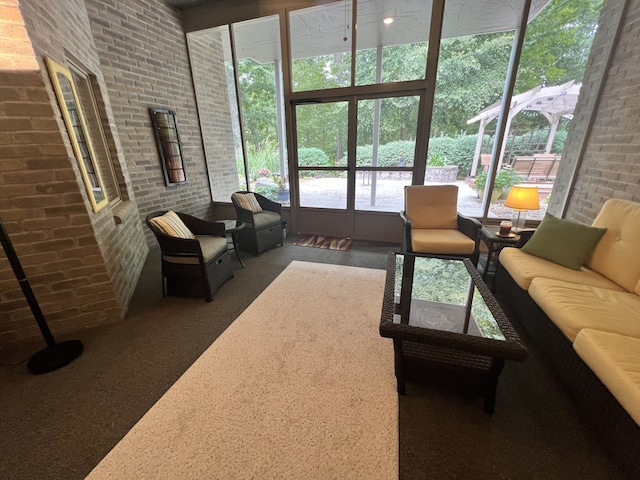 living room with a towering ceiling and brick wall