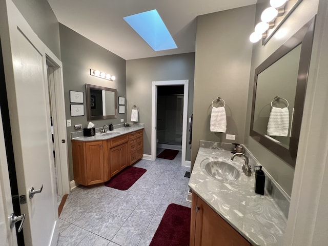 bathroom with vanity, a skylight, and tile patterned flooring