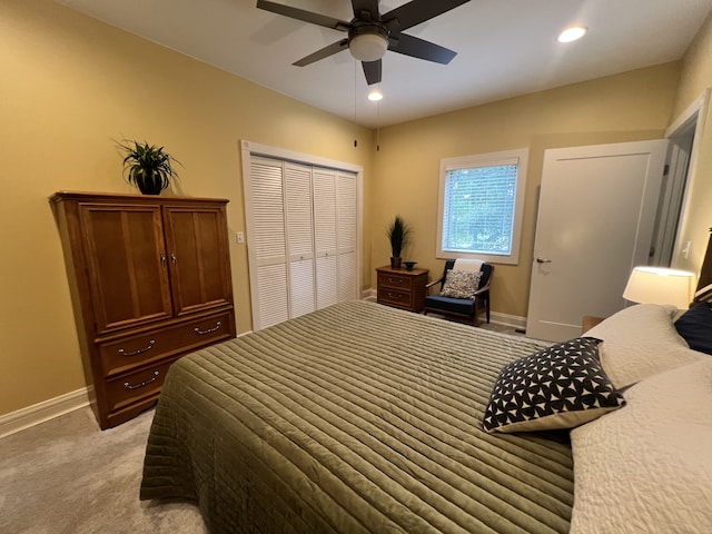 bedroom featuring ceiling fan, a closet, and light carpet