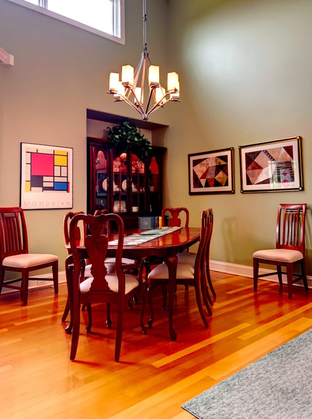 dining room with an inviting chandelier and wood-type flooring