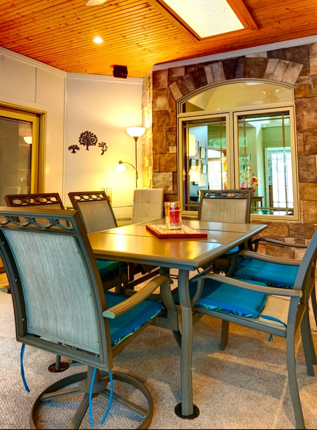 dining area with ornamental molding, wood ceiling, and carpet