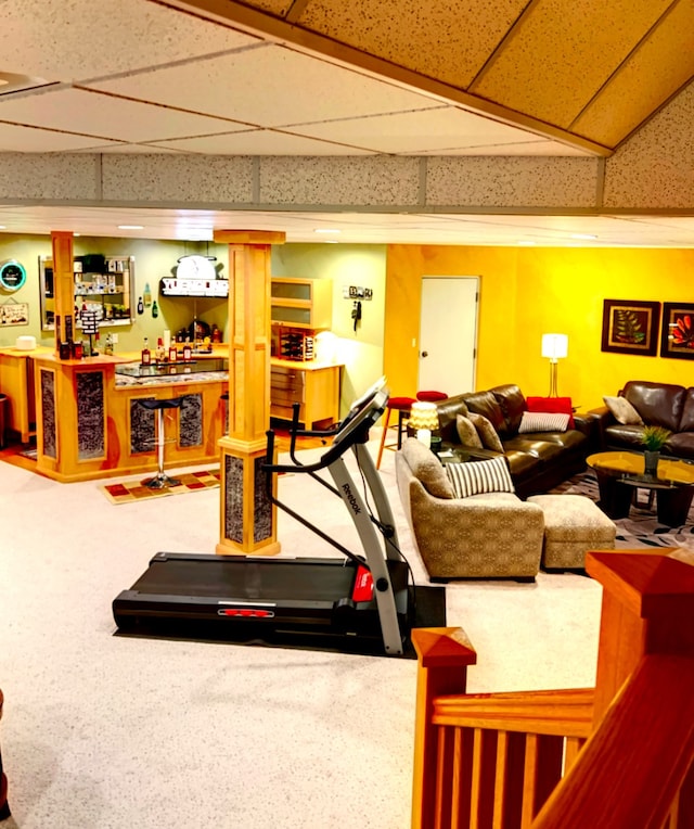 carpeted living room featuring bar and a drop ceiling