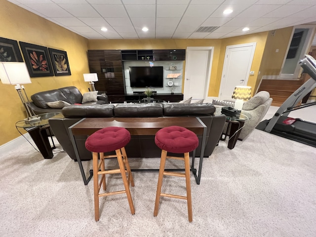 carpeted living room with a drop ceiling