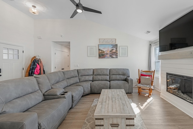 living room with light wood-type flooring, ceiling fan, and vaulted ceiling