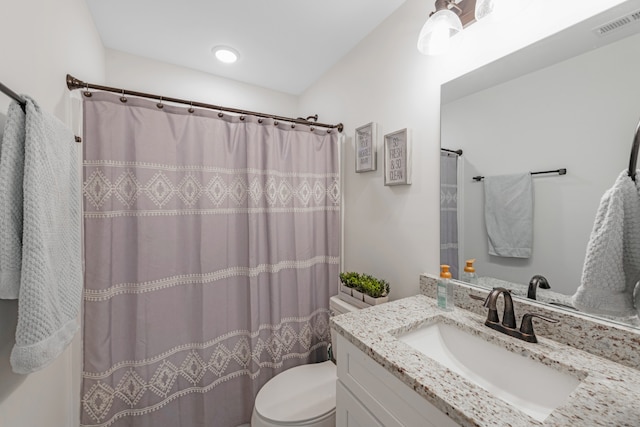 bathroom featuring vanity, toilet, and walk in shower