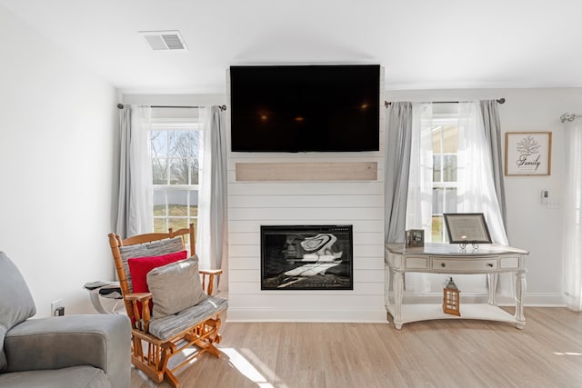 interior space featuring a large fireplace and light hardwood / wood-style flooring