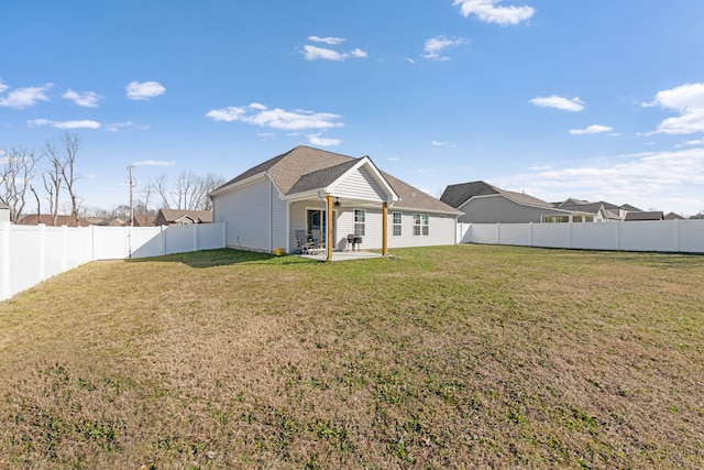 back of house featuring a patio area and a lawn