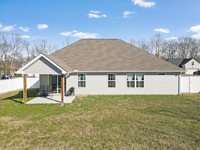 rear view of house featuring a lawn and a patio