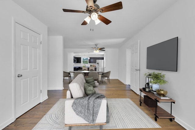 living room with hardwood / wood-style floors and ceiling fan