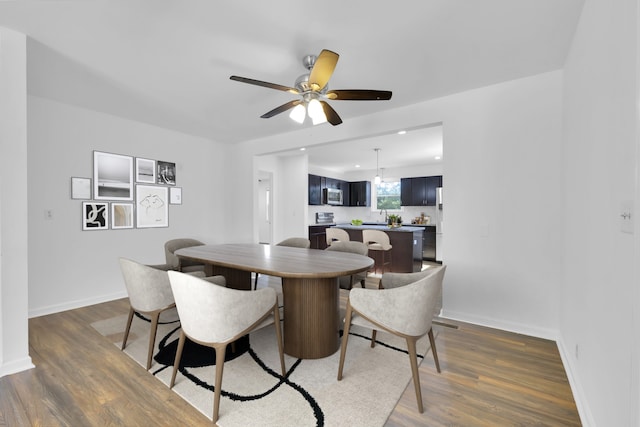 dining room with ceiling fan and dark hardwood / wood-style flooring