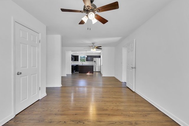 unfurnished living room featuring dark hardwood / wood-style flooring and ceiling fan