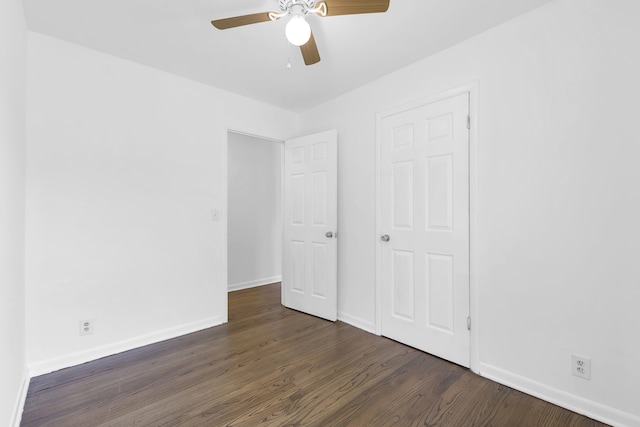 unfurnished bedroom featuring ceiling fan and dark wood-type flooring