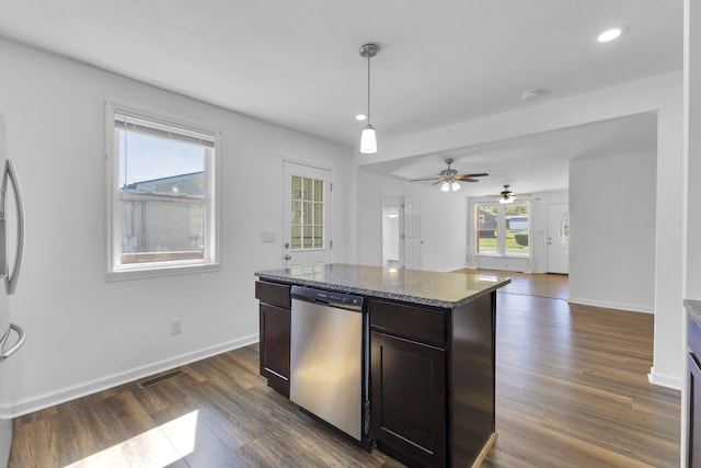 kitchen featuring dark brown cabinetry, stainless steel dishwasher, dark wood-type flooring, pendant lighting, and dark stone counters