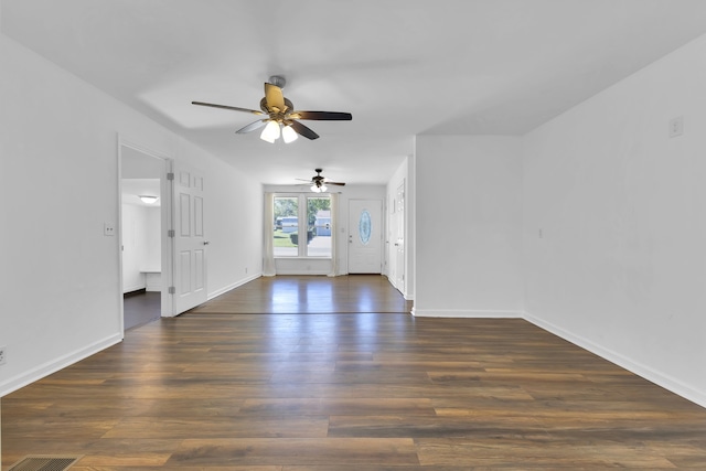 spare room featuring ceiling fan and dark wood-type flooring