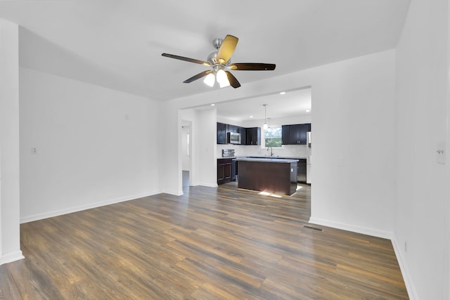 unfurnished living room with ceiling fan, sink, and dark hardwood / wood-style flooring