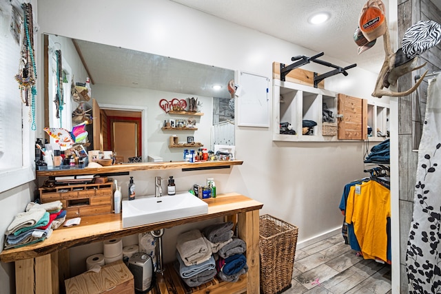 bathroom with wood-type flooring, a textured ceiling, and sink