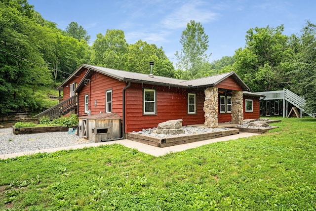 back of house featuring a lawn and a deck